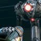 A damaged E.M.M.I., with Samus' blaster arm pointed at it in the foreground.
